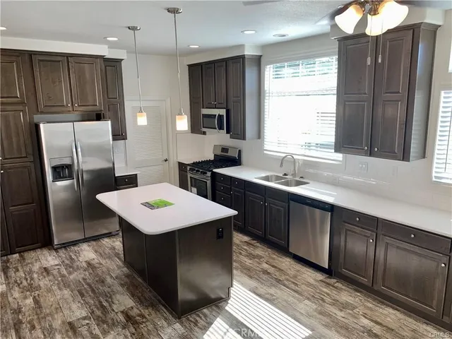 a kitchen with a sink a counter top space stainless steel appliances and a window