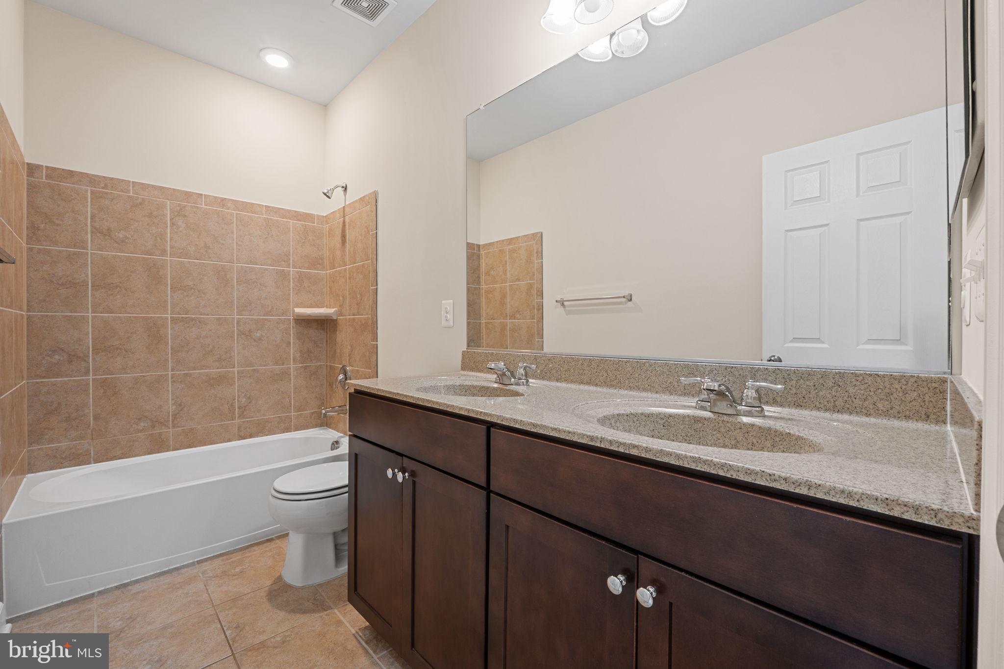 803 Holden Road Frederick, MD 21701 - Photo 35 of 63 a bathroom with a granite countertop sink a toilet and bathtub