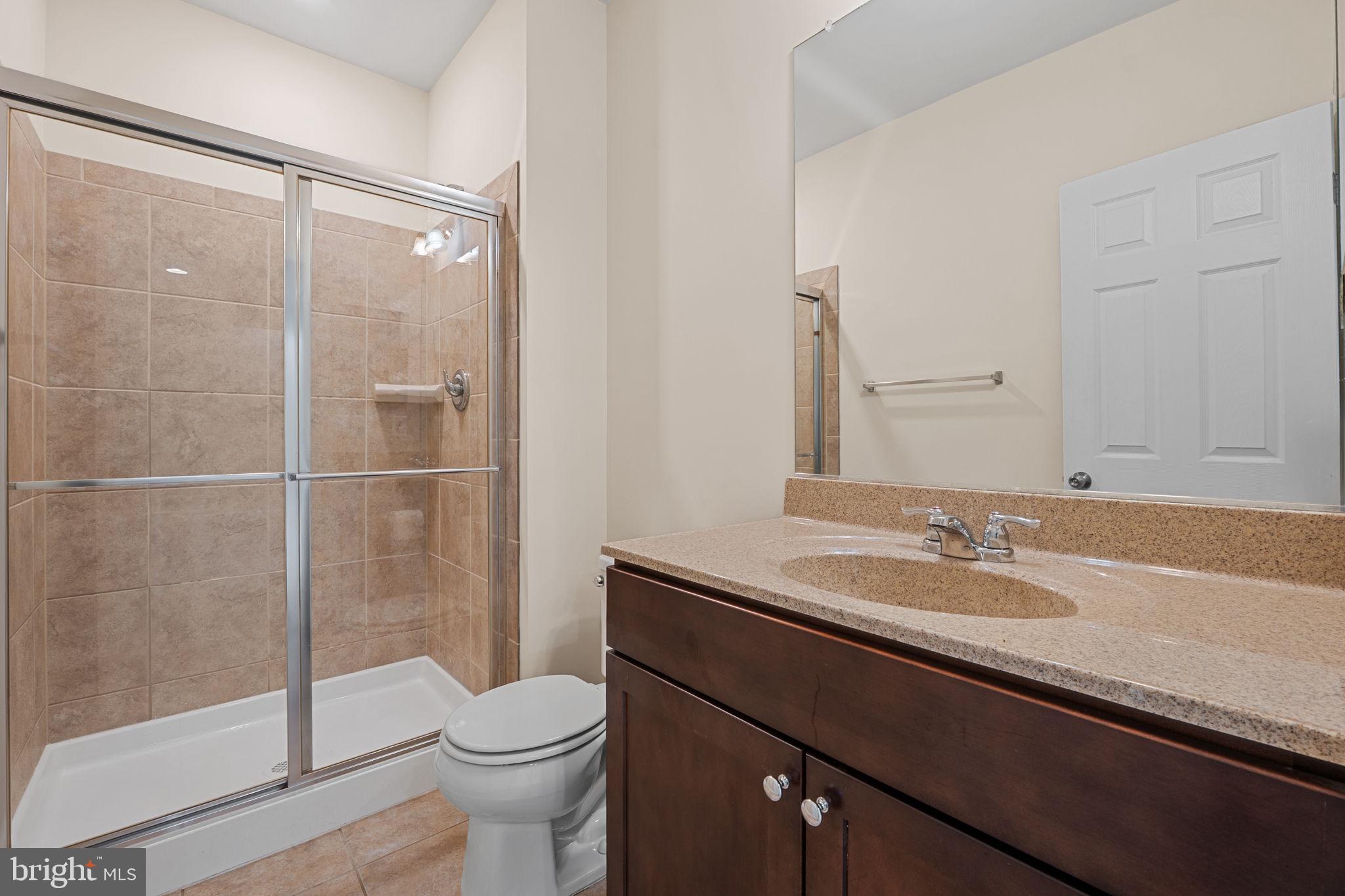 803 Holden Road Frederick, MD 21701 - Photo 47 of 63 a bathroom with a granite countertop sink toilet and shower