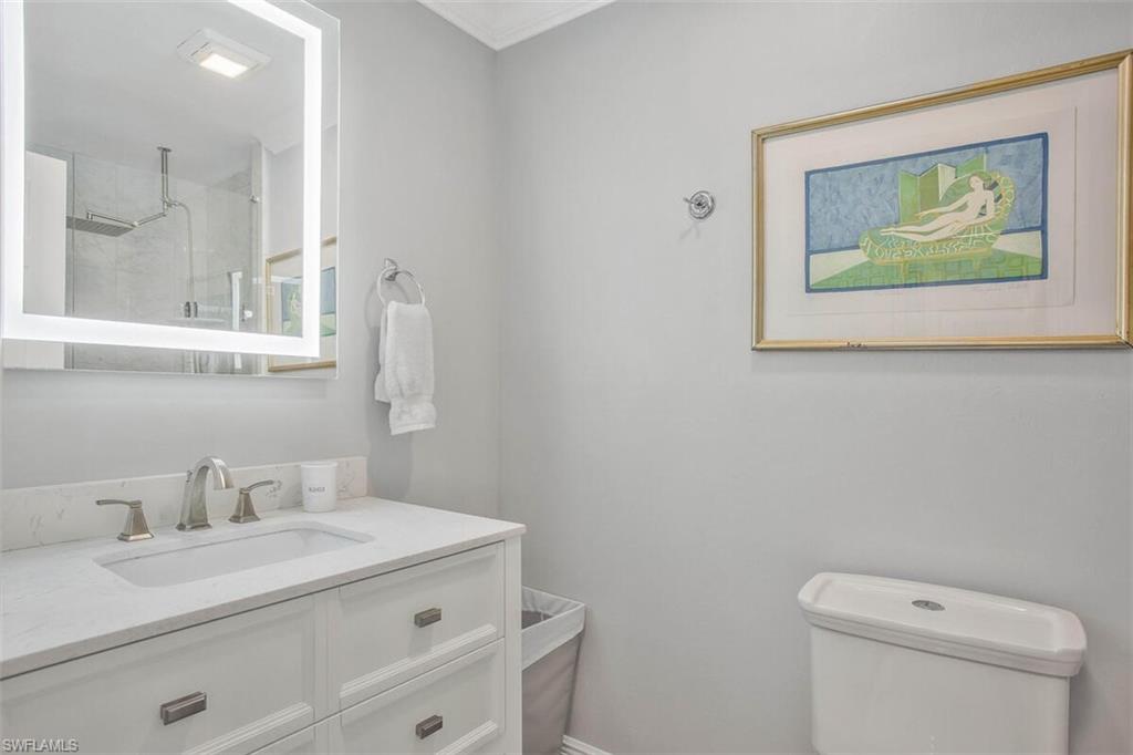 910 Vanderbilt Beach Road, Unit 123W Naples, FL 34108 - Photo 15 of 33 Bathroom with vanity, a shower, crown molding, and toilet