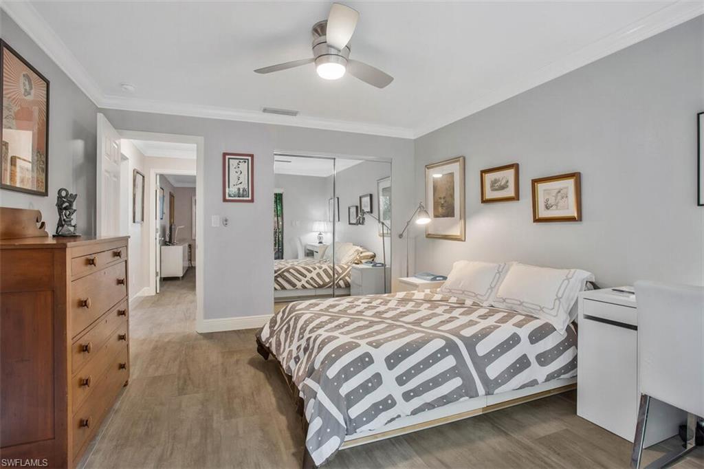 910 Vanderbilt Beach Road, Unit 123W Naples, FL 34108 - Photo 18 of 33 Bedroom with ceiling fan, hardwood / wood-style flooring, a closet, and crown molding