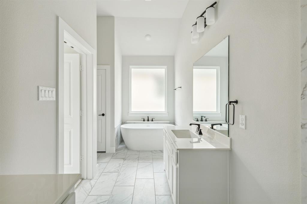 6145 Tahoe Winds Drive Pilot Point, TX 76258 - Photo 17 of 28 a spacious bathroom with a double vanity sink mirror and bathtub