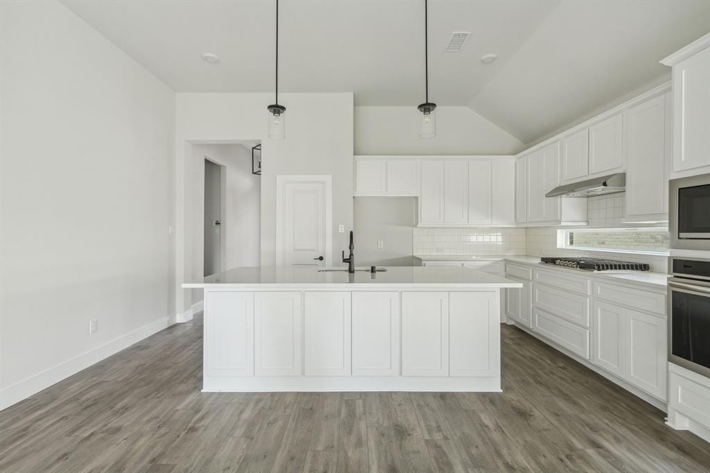 6145 Tahoe Winds Drive Pilot Point, TX 76258 - Photo 5 of 28 a kitchen with stainless steel appliances a sink a stove a refrigerator and white cabinets
