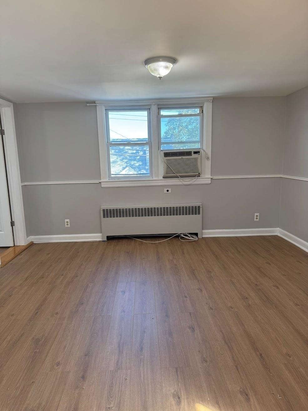 177 Huber Street, Unit 2 Secaucus, NJ 07094 - Photo 3 of 13 an empty room with wooden floor and windows