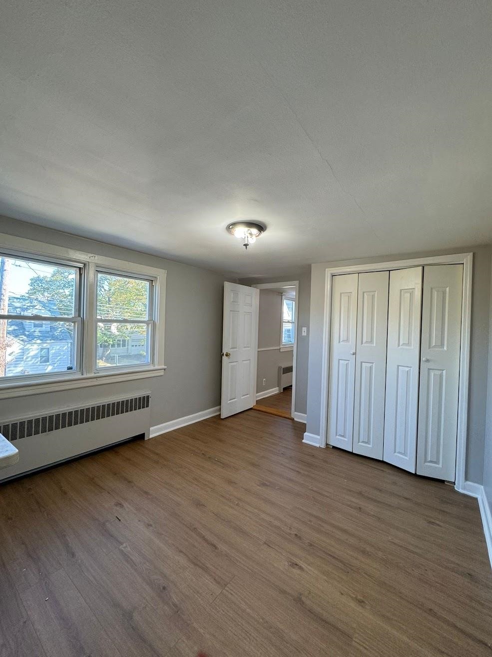 177 Huber Street, Unit 2 Secaucus, NJ 07094 - Photo 5 of 13 an empty room with wooden floor and windows