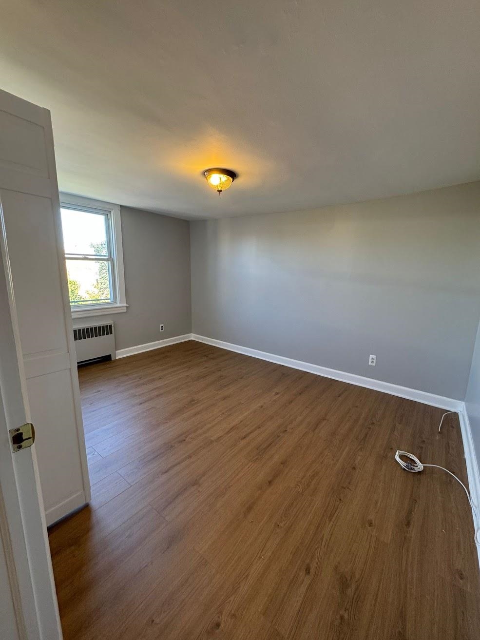 177 Huber Street, Unit 2 Secaucus, NJ 07094 - Photo 7 of 13 wooden floor in an empty room with a window