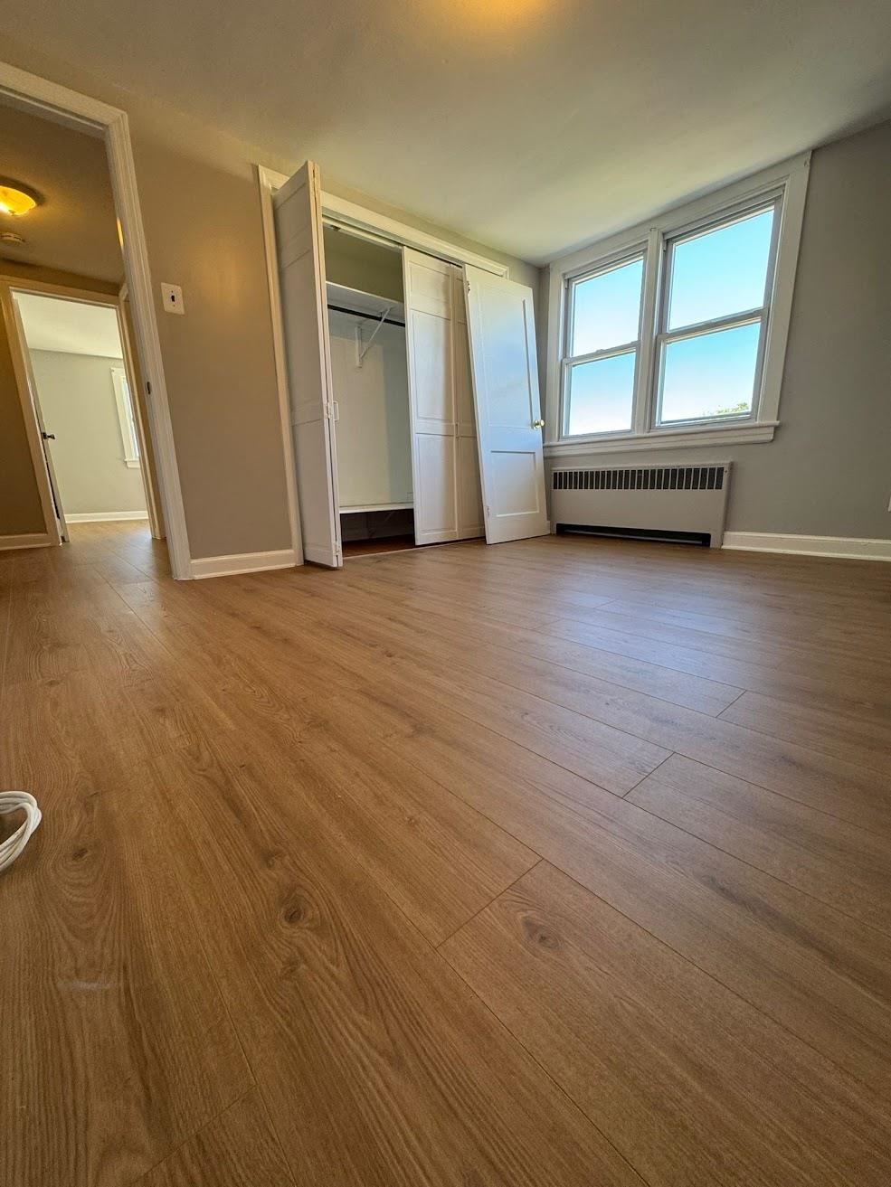 177 Huber Street, Unit 2 Secaucus, NJ 07094 - Photo 8 of 13 an empty room with wooden floor and windows