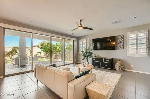 a living room with furniture a flat screen tv and a large window