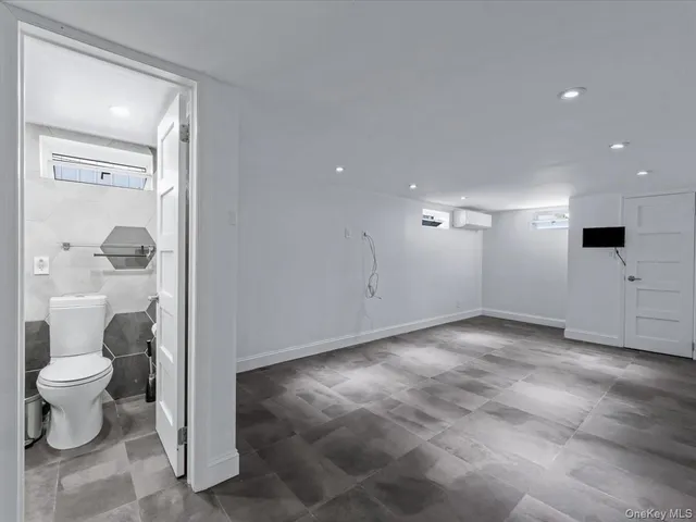 a view of a hallway with toilet and sink