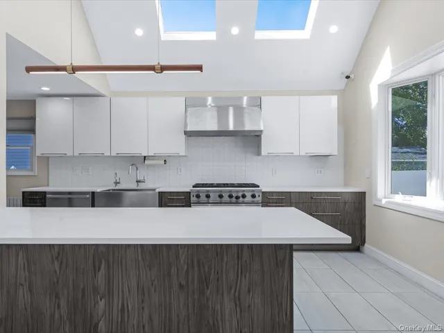 a kitchen with stainless steel appliances granite countertop a sink a stove and a refrigerator