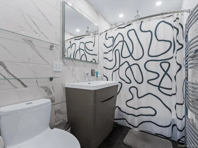 a bathroom with a sink and mirror with toilet