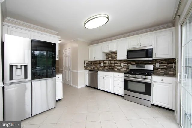 a kitchen with stainless steel appliances a stove a sink and a microwave