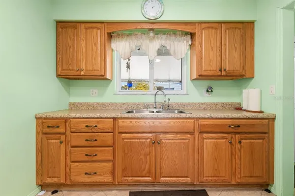 a kitchen with granite countertop a sink and a wooden cabinets