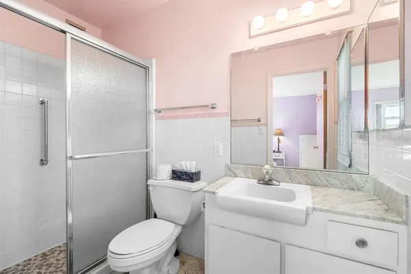 a bathroom with a sink a toilet and shower