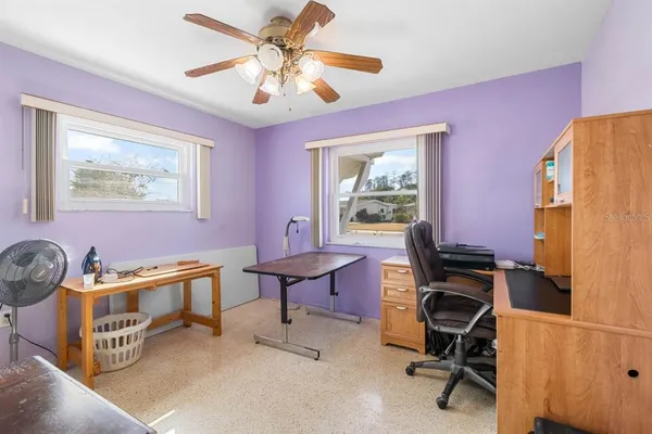 a view of a livingroom with workspace and a window