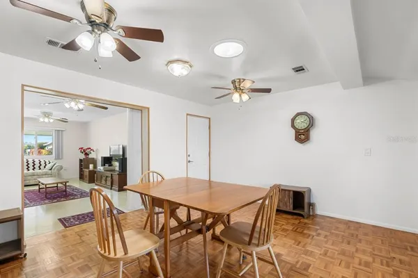a view of a dining room with furniture and a chandelier fan