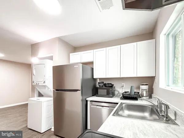 a kitchen with a refrigerator sink and cabinets