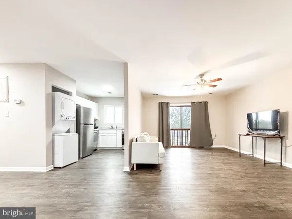 a living room with furniture and a kitchen