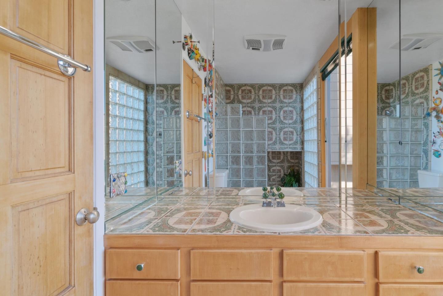 7625 Oak Ridge Road Aptos, CA 95003 - Photo 45 of 67 a bathroom with a granite countertop sink a mirror and a shower