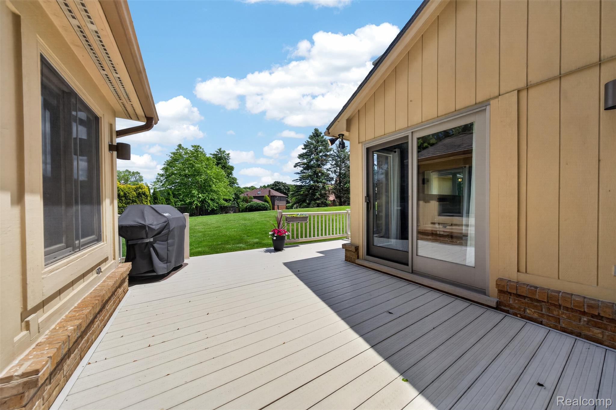 1236 Chaffer Drive Rochester, MI 48306 - Photo 62 of 76 Expansive outdoor deck featuring wood-finish flooring, sliding glass doors, a perimeter railing, and broad green landscaping