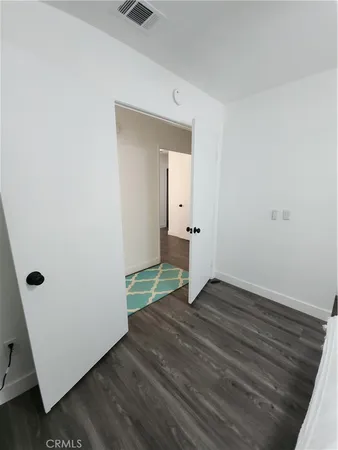an empty room with wooden floor and mirror