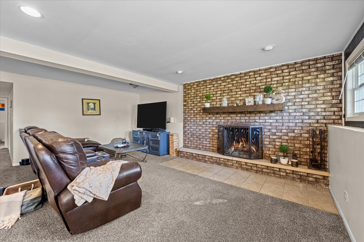 2-n651 Beith Road Elburn, IL 60119 - Photo 18 of 24 a living room with furniture a fireplace and a flat screen tv