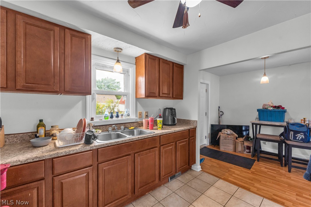 30015 Warren Road Wickliffe, OH 44092 - Photo 6 of 23 Warm wood cabinetry with raised-panel doors and granite countertops define this kitchen, which features stainless steel appliances, pendant lighting, and abundant counter workspace