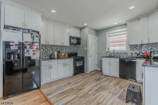 a kitchen with stainless steel appliances kitchen island granite countertop a refrigerator and a stove top oven