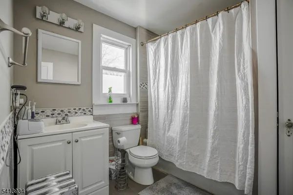 a bathroom with a sink toilet and window
