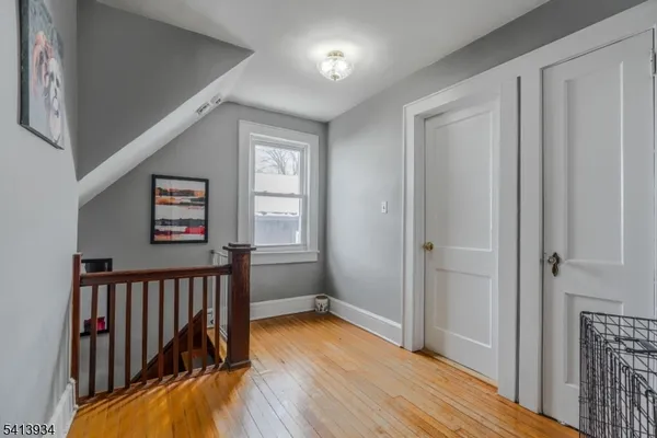 a view of a hallway with wooden floor and stairs
