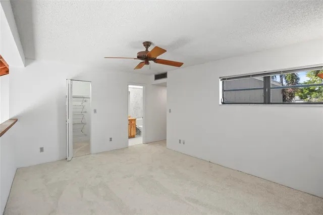 a view of a room with a ceiling fan and a window