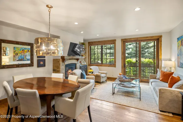 a dining room with furniture a chandelier and wooden floor