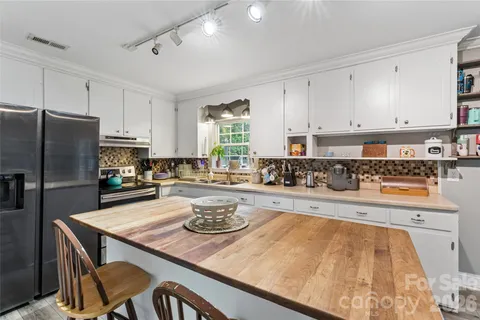 a kitchen with a table chairs stove and refrigerator