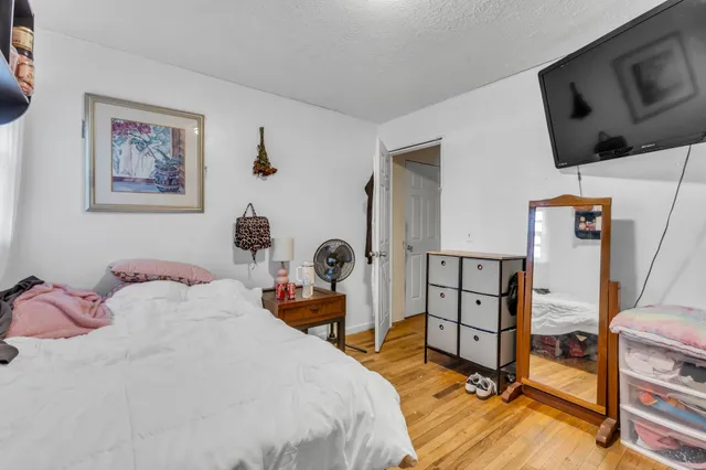 a bedroom with a bed a couch and a flat screen tv