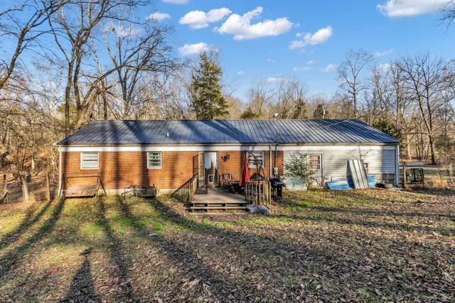 a view of a house with backyard and a tree