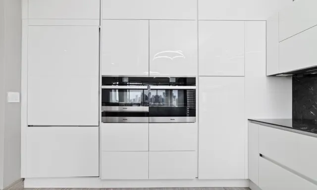 a kitchen with granite countertop white cabinets and stainless steel appliances