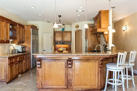 a kitchen with kitchen island granite countertop wooden cabinets and stainless steel appliances