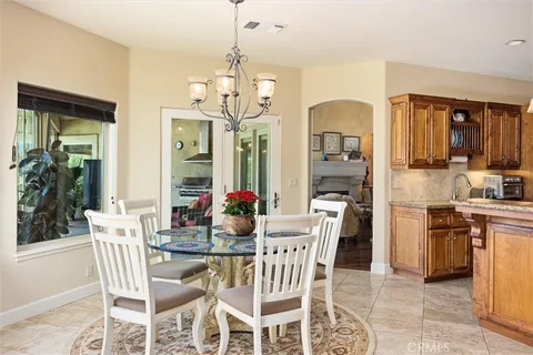 a view of a dining room with furniture a chandelier and kitchen view