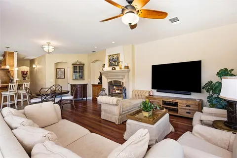 a living room with furniture a flat screen tv and a fireplace