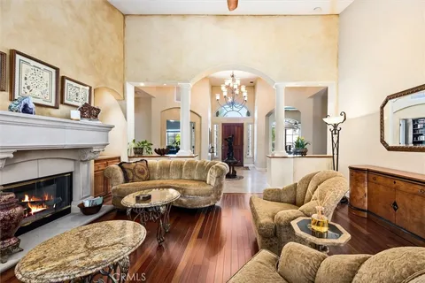 a living room with furniture a fireplace a rug and a large window