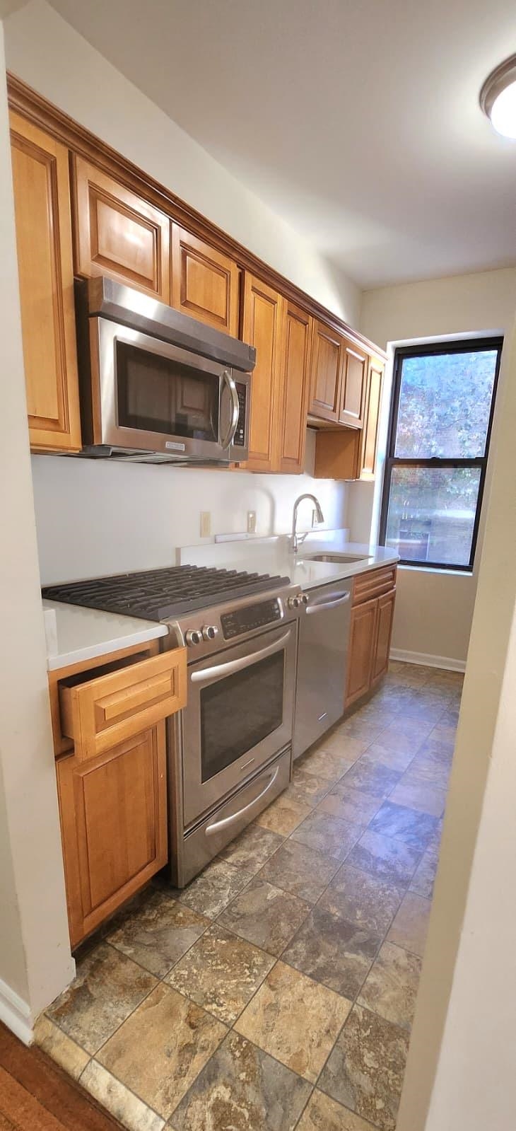 761 Avenue A, Unit 5 Bayonne, NJ 07002 - Photo 2 of 12 a kitchen with stainless steel appliances granite countertop a stove a sink and a microwave