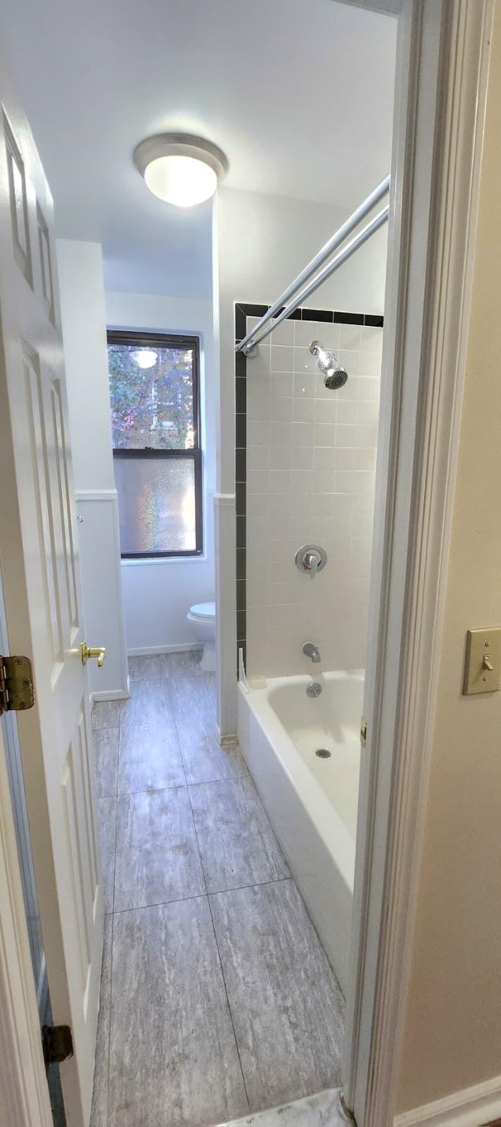 761 Avenue A, Unit 5 Bayonne, NJ 07002 - Photo 4 of 12 a bathroom with a bathtub a toilet and a shower