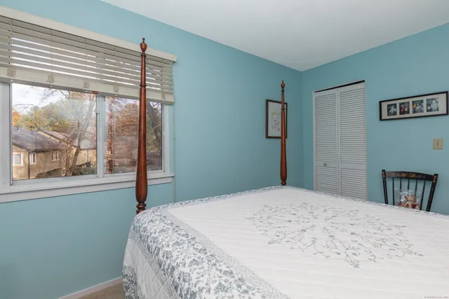 a bedroom with a bed and a large window