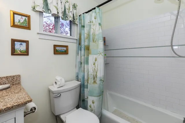 a bathroom with a granite countertop toilet and a shower