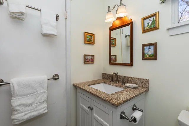 a bathroom with a granite countertop sink and a mirror