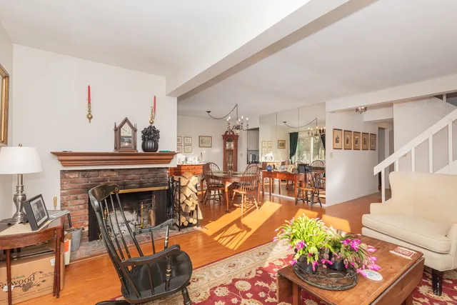a living room with furniture a fireplace and a chandelier