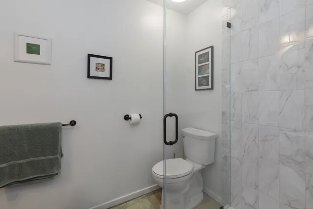 a white toilet sitting next to a shower