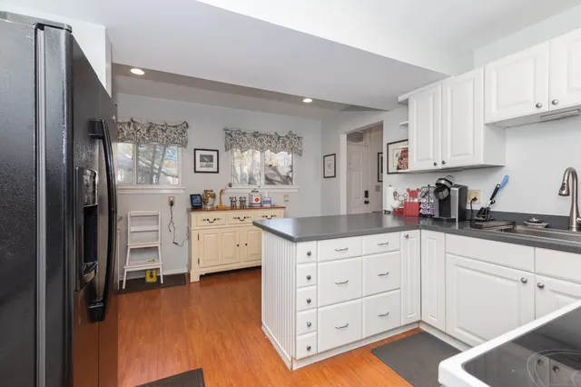 a kitchen with granite countertop a sink cabinets and wooden floor