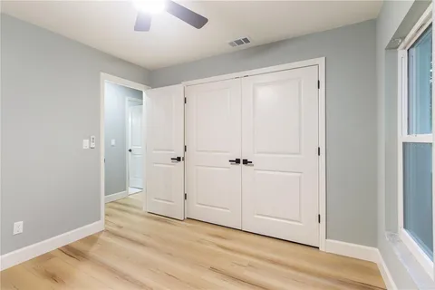 a view of a hallway with wooden floor and closet