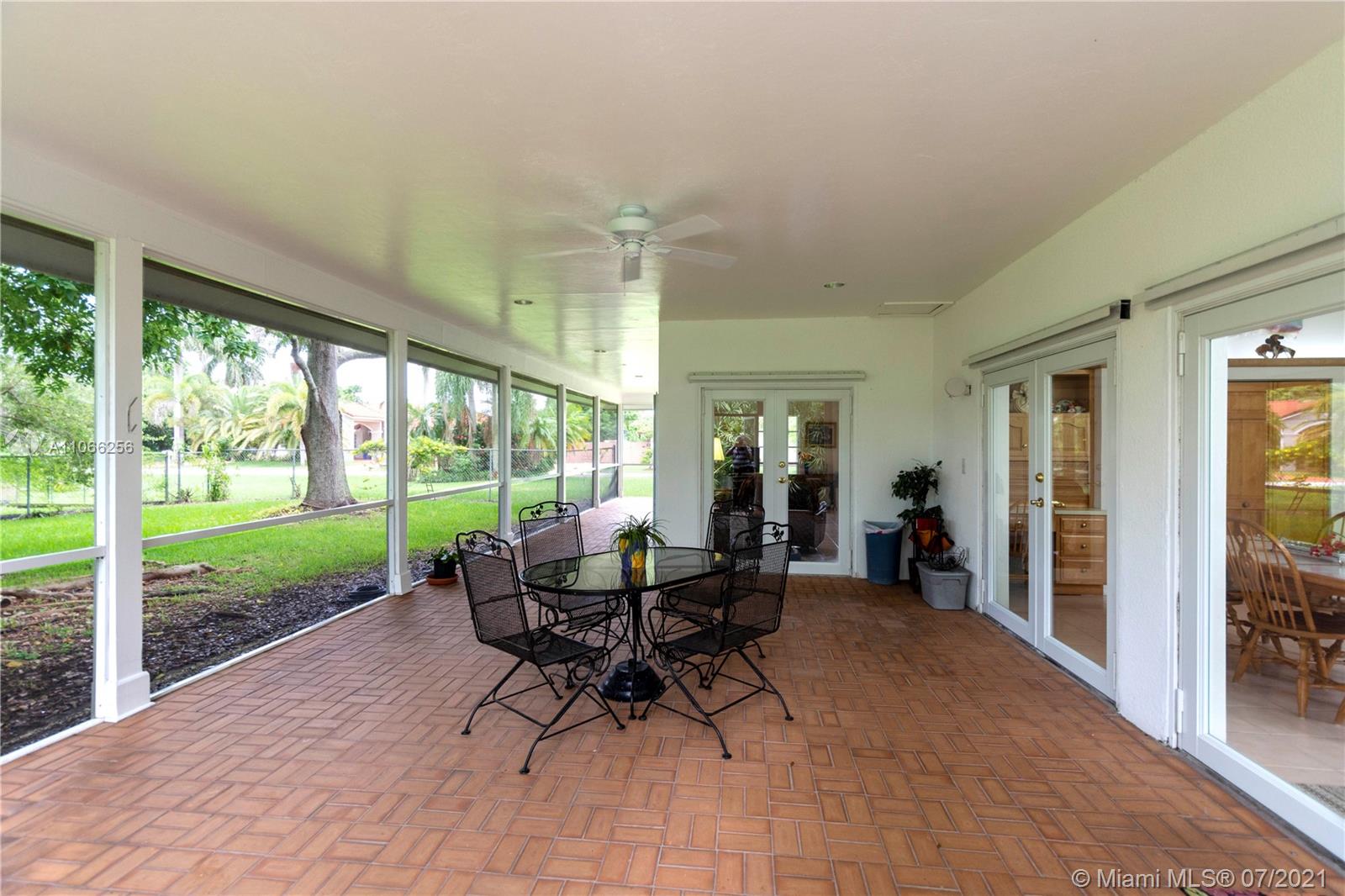 16721 Southwest 278th Street Homestead, FL 33031 - Photo 15 of 20 a view of a patio with table and chairs floor to ceiling window and yard